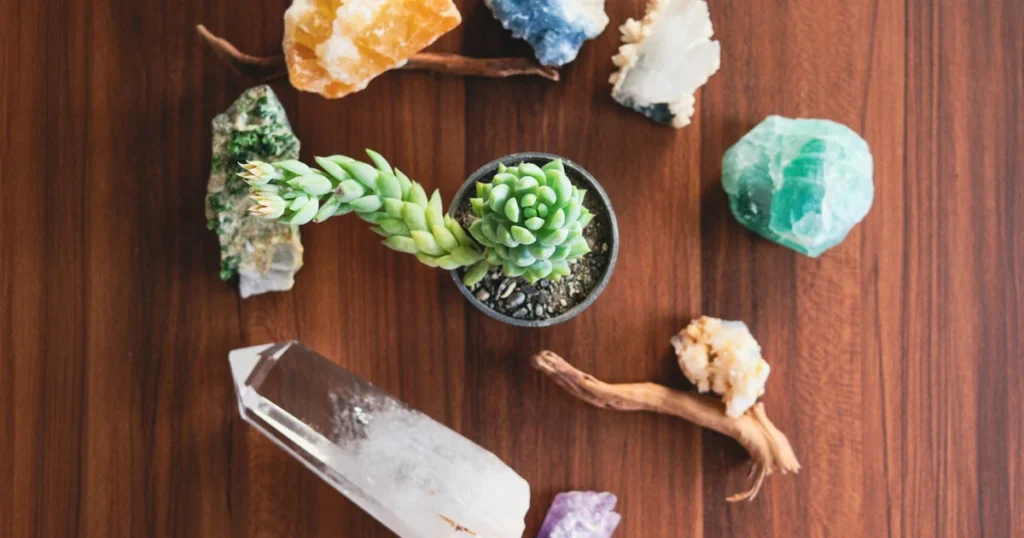 Woman sorting through raw amethyst and quartz crystals on fabric in her bedroom during daylight